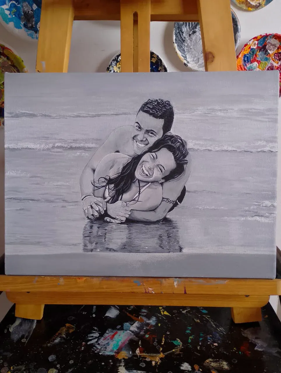 Retrato en blanco y negro de una pareja abrazada en la orilla del mar