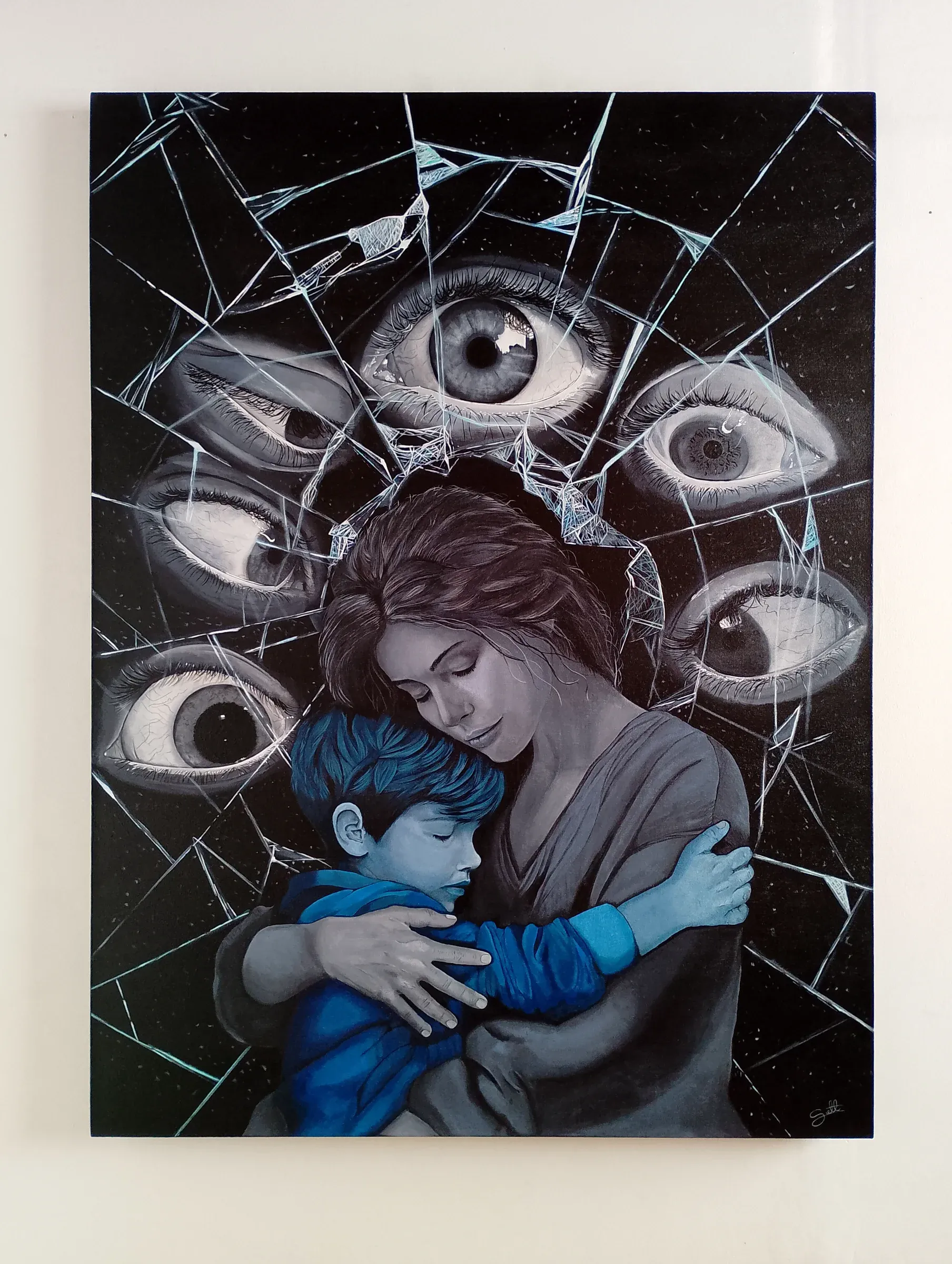 Mujer abraza a un niño de sudadera azul entre fragmentos de espejo roto y grandes ojos pintados